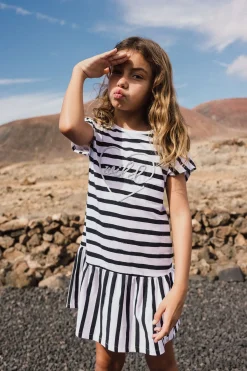 Abito in maglia per bambina con design a righe in bianco e nero.