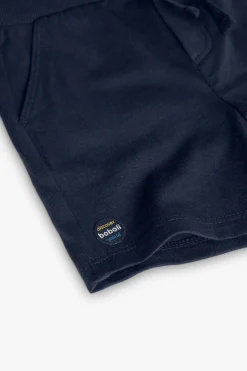Completo di maglietta e pantaloncini in maglia per bambino in colore bianco.