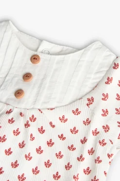 Completo in maglia per neonata con stampa floreale in rosso.