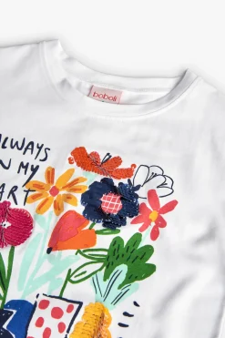 Maglietta a maglia per bambina in bianco con stampa floreale.