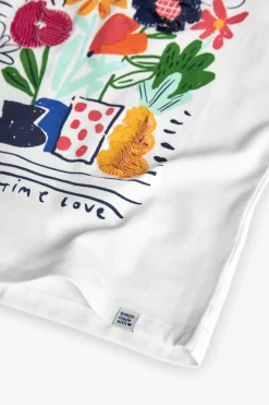 Maglietta a maglia per bambina in bianco con stampa floreale.