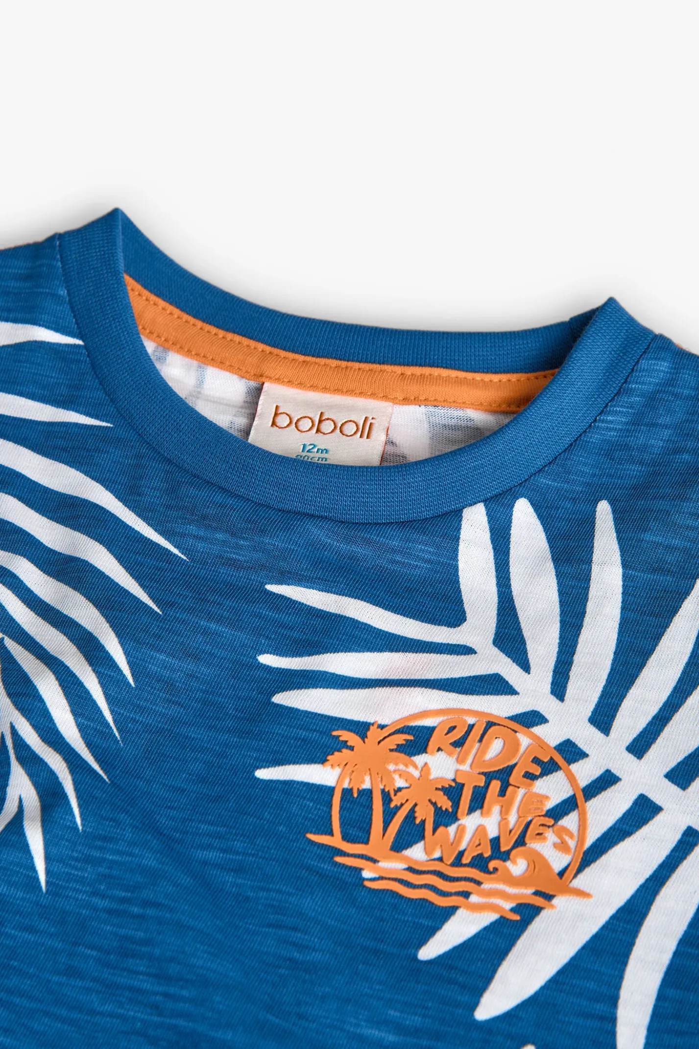 Maglietta in maglia per bambino di colore blu con design tropicale.