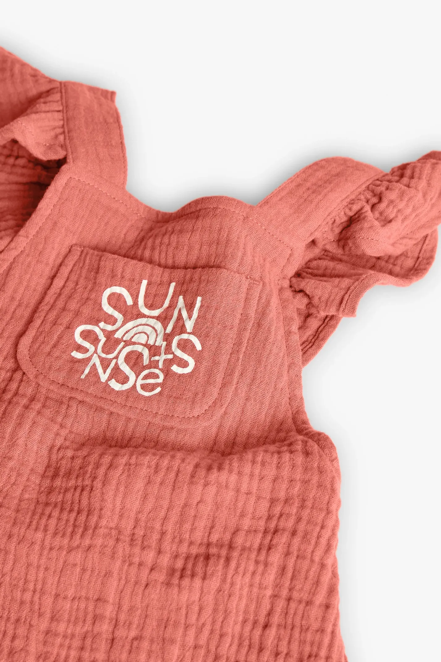 Pagliaccetto a maglia per bambina in colore arancione.