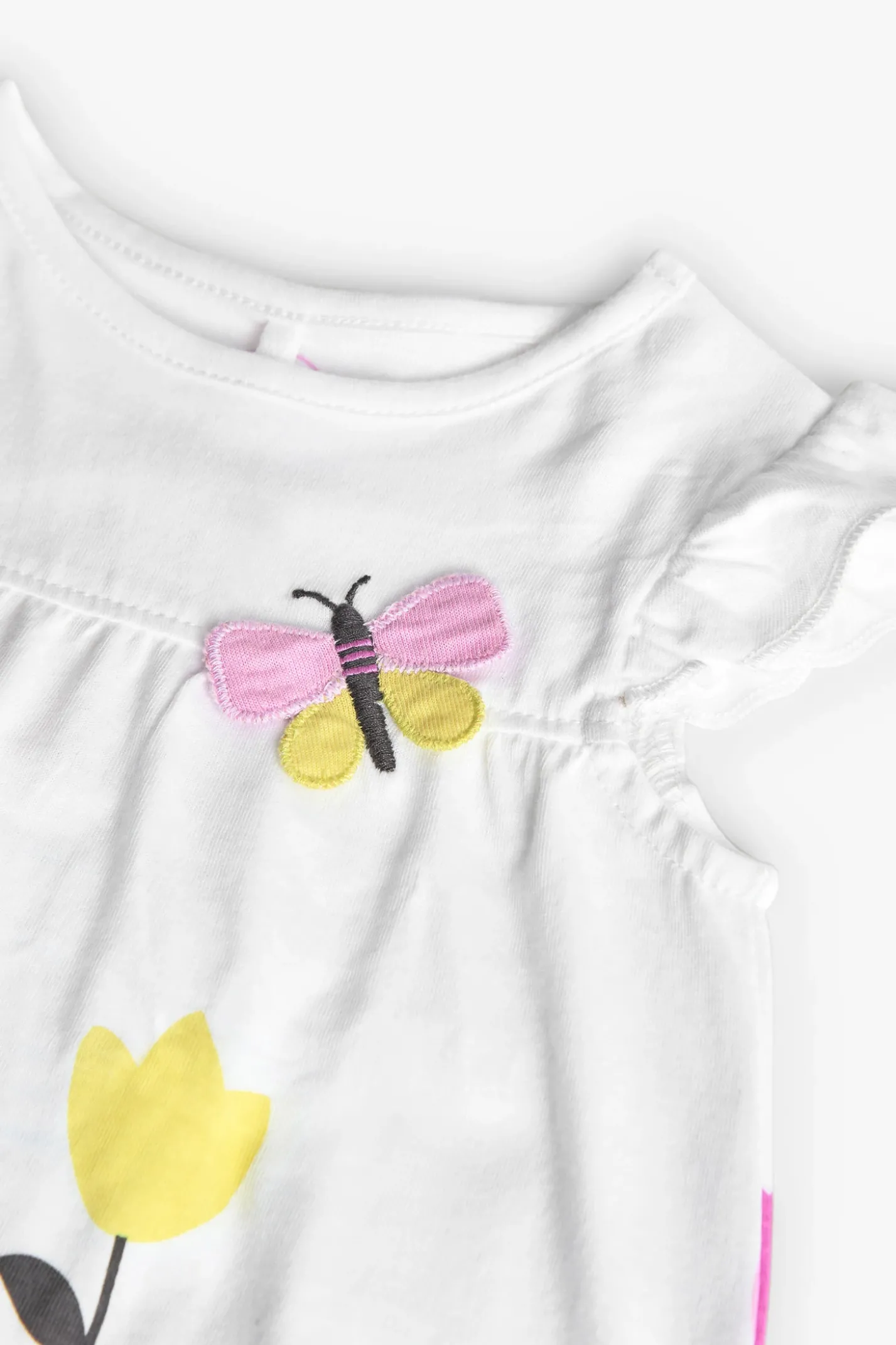 Pagliaccetto in maglia per bambina con stampa floreale in bianco.