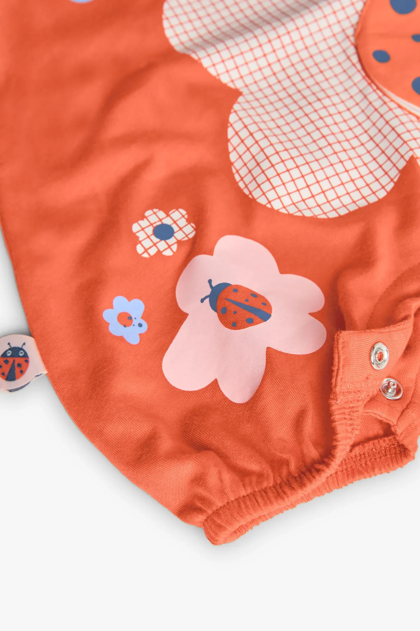 Pagliaccetto in maglia per neonata in colore rosso con design di coccinella.