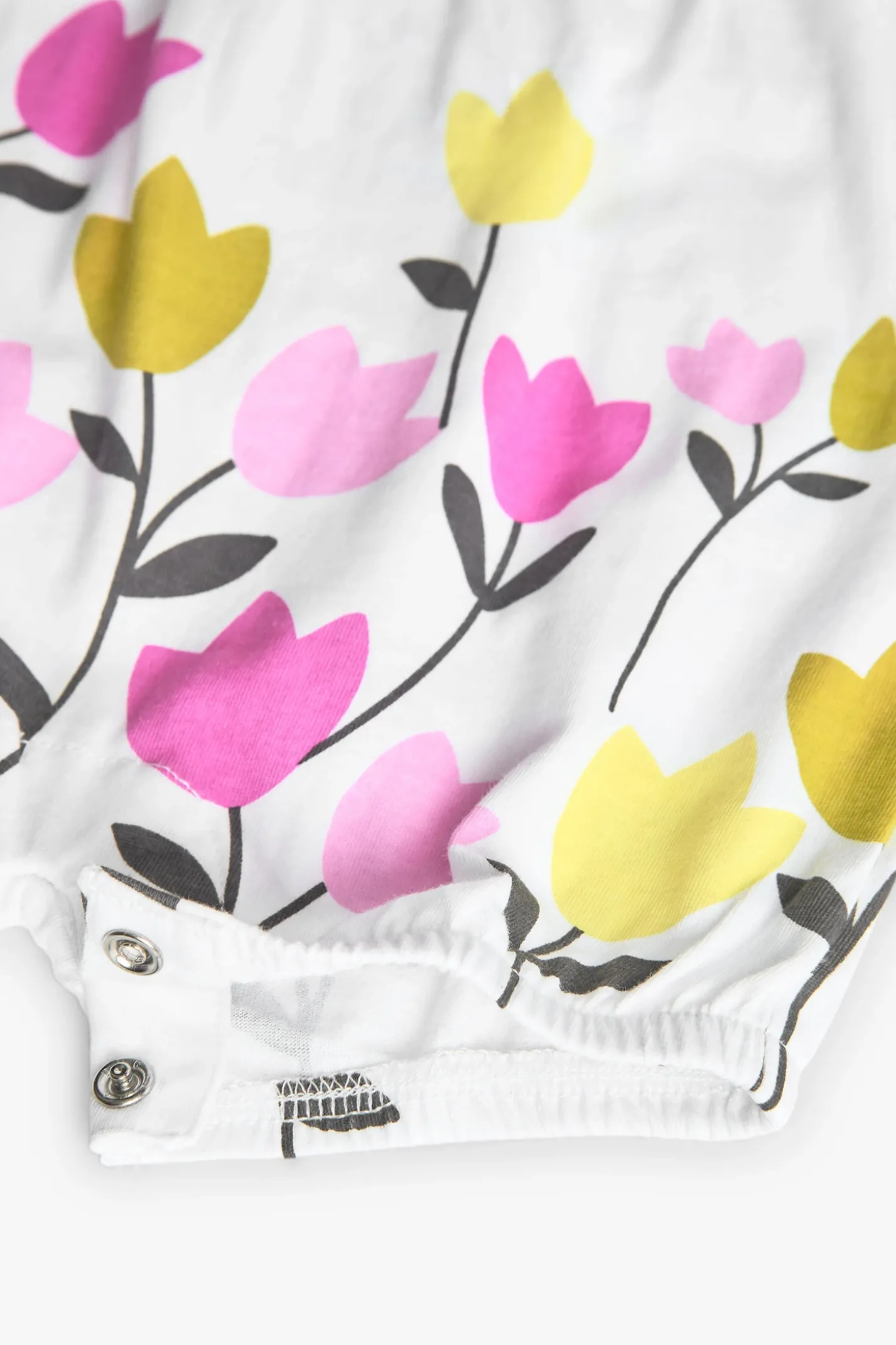 Pagliaccetto in maglia per bambina con stampa floreale in bianco.