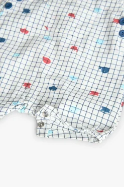 Salopette in popeline per bambino in colore bianco con stampa a quadri in blu e rosso.