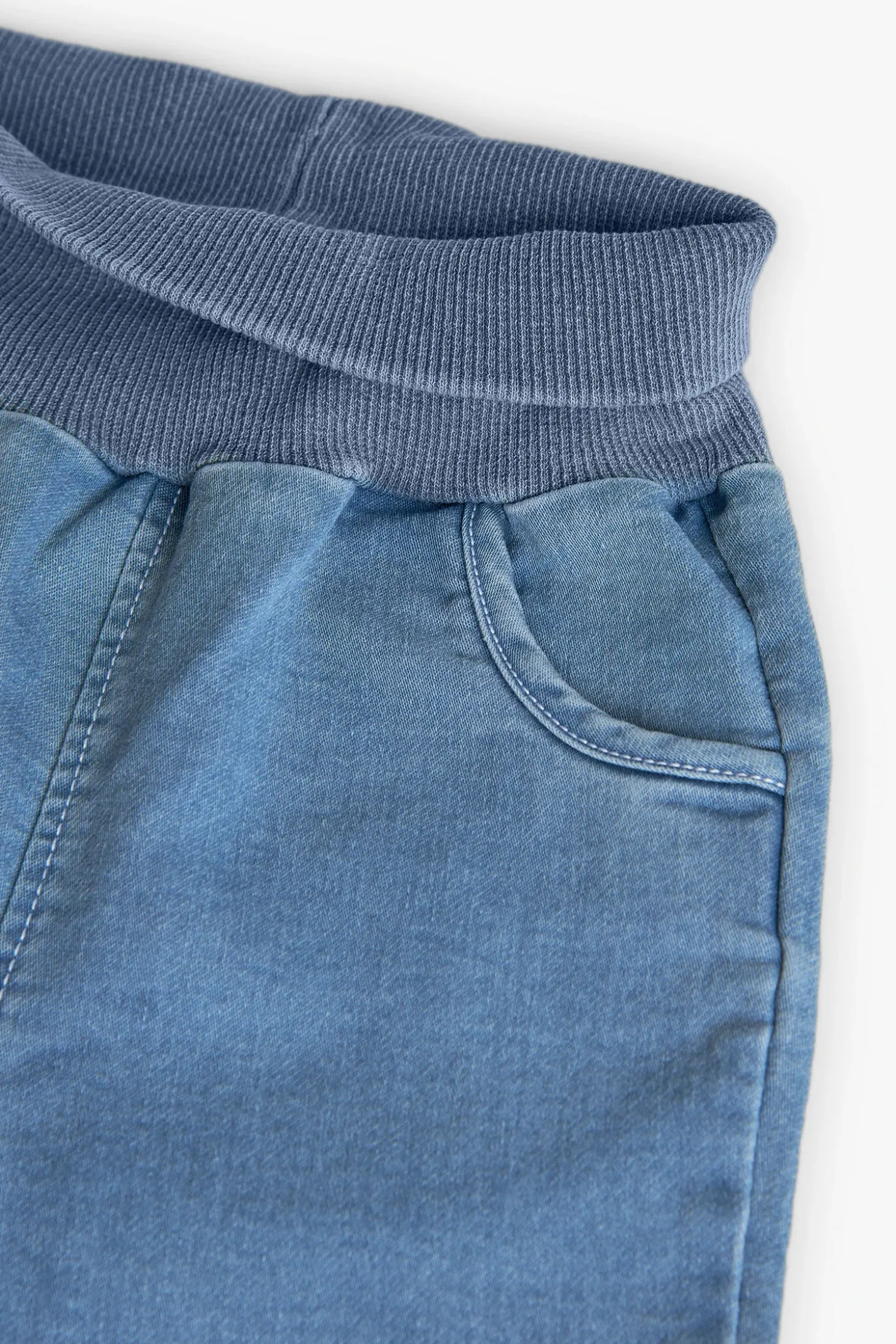 Set di maglietta e pantaloni in maglia per neonato di colore bianco.