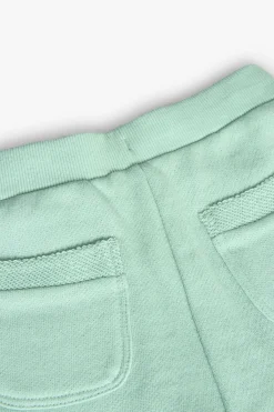 Shorts in felpa per bambina di colore verde.