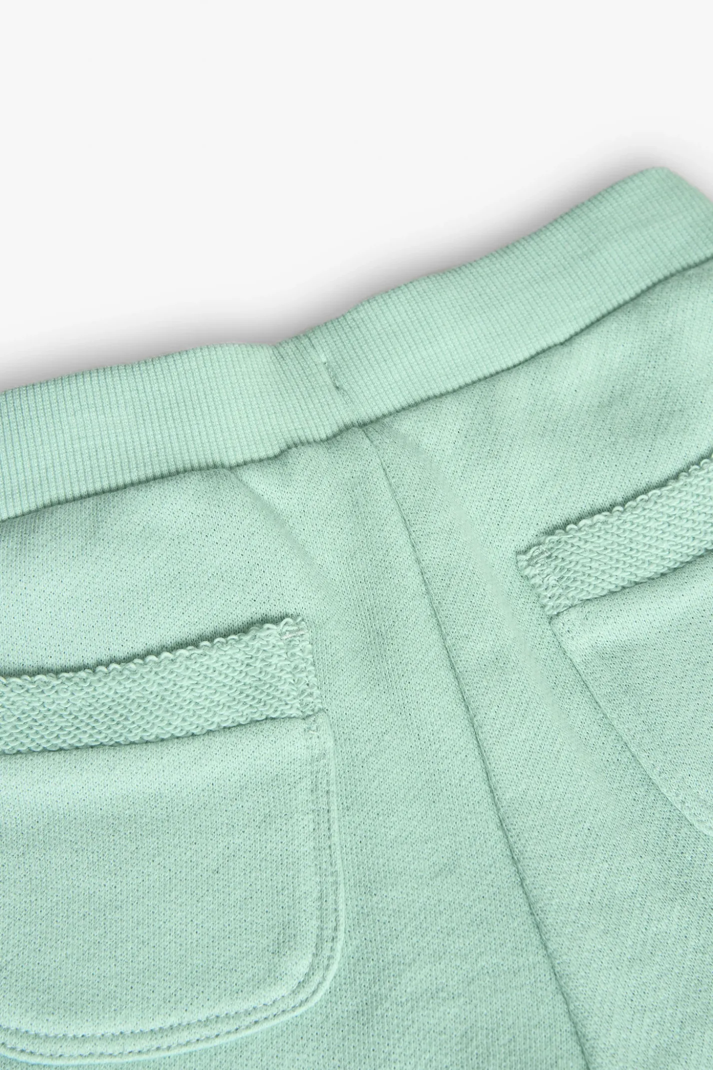 Shorts in felpa per bambina di colore verde.