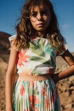 Tuta di chiffon plissettato per bambina con motivo floreale nei colori rosa e verde.