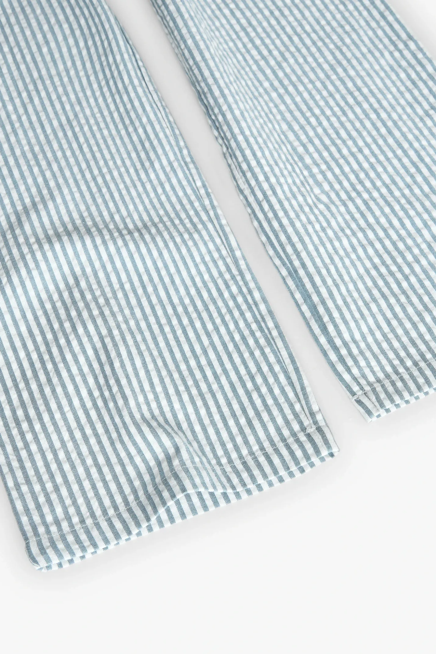 Tuta in popeline per bambina a righe in blu e bianco.