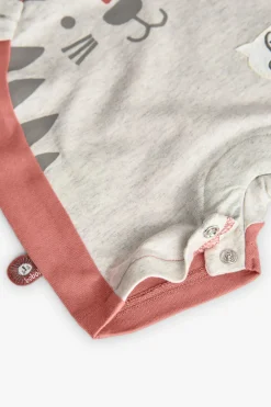 Tutina corta in maglia per bebé di colore arancione.